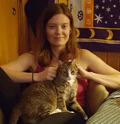 hilary-sitting-with-cat-lola Kvinde i lyserød skjorte sidder med en kat på skødet