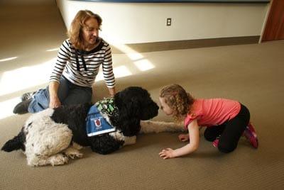 Laure Seiber og hendes terapihund Charlie arbejder med et barn på Barber National Institute i Erie, Pa.